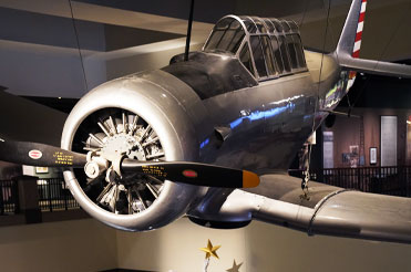 Gray AT-6 airplane suspended from the ceiling in the Bullock Museum