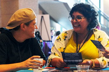 two adults sitting at a table talking and smiling in the Bullock Museum