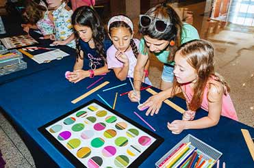 two children and an adult doing a craft at the Bullock Museum