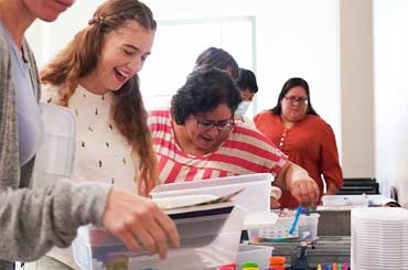 group of adults smiling and looking through educational materials