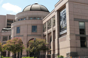 Exterior of Bullock Museum made of brown and red granite with a dome