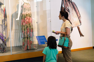 woman and child looking at floral printed dress in Fashion Forward exhibit