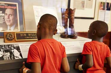two children standing in front of artifacts from Bob Bullock's life in the Bullock Museum