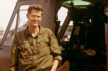 Vietnam medic in his uniform standing next to a helicopter
