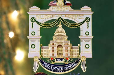 Christmas ornament of the Texas State Capitol hanging on a tree