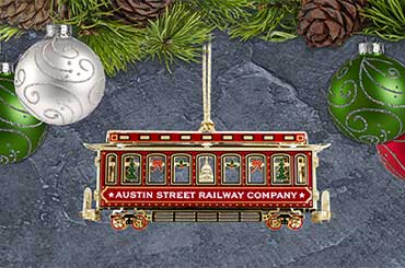 ornament of a red and gold trolley handing from garland