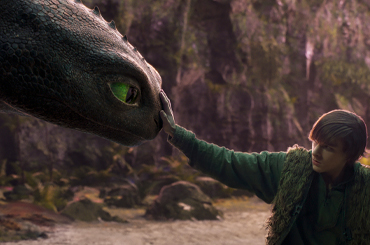 a young boy touching a dragon's nose.