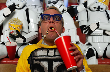 film poster for "In the Lone Star Wars State" of a person sitting in a movie theater a large drink with Clone Troopers in the background