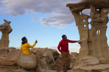 two people in a rocky landscape, one person is leaning against a tall large rock in the film "Into America's Wild"