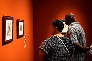 two adults looking at artwork in the Kelley Art Collection exhibit in the Bullock Museum