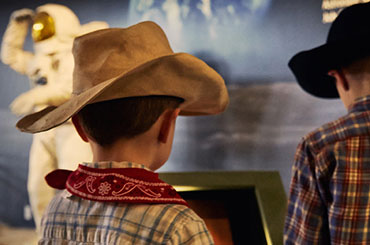 two young boys wearing cowboy hats.