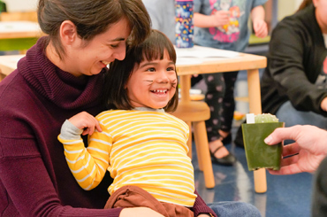 a child reaching for a plant during an activity at the Bullock Museum.
