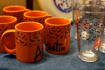 orange mugs with bats on them in the Bullock Museum Store