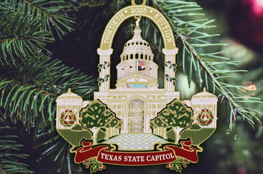 an ornament in the shape of the Texas State Capitol hanging from a Christmas tree.