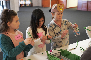 three children doing crafts together at the Bullock Museum.