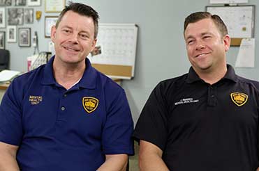 two men sitting down from the film "Ernie & Joe Crisis Cops"