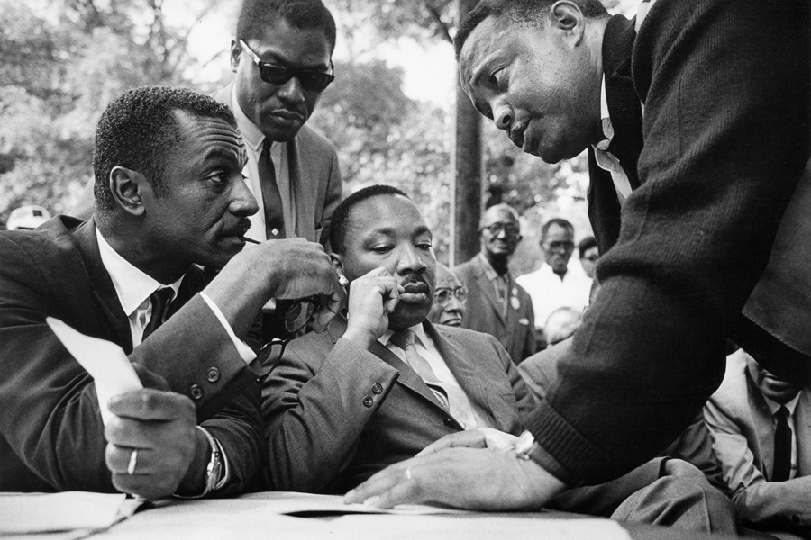 ) Rev. Fred Shuttlesworth, Bernard Lee, Rev. Martin Luther King, and Hosea Williams confer during a rally in Kelly Ingram Park.