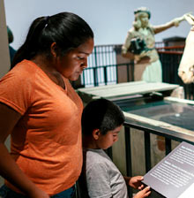 Woman and child reading placard